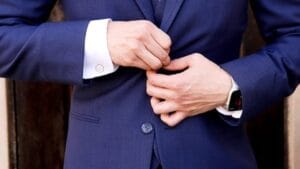 Mies sulkee puvun nappeja älykello ranteessa