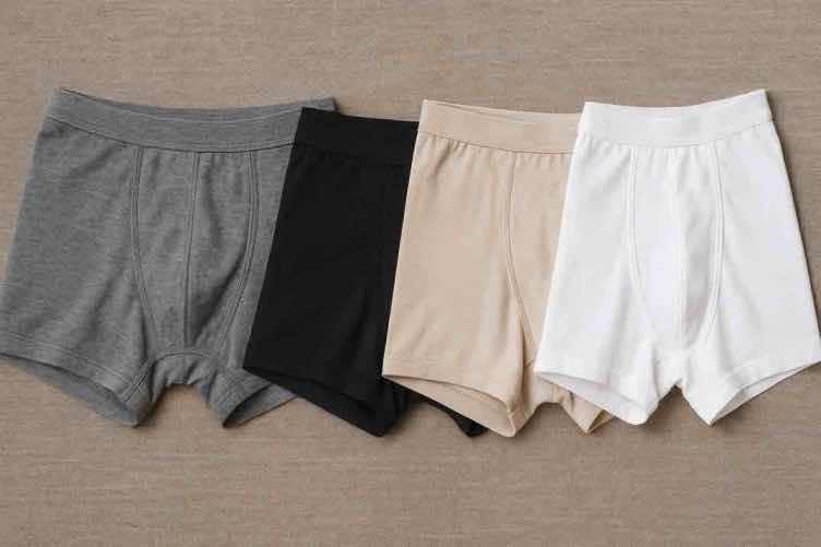 Miesten alushousut eri materiaaleista vierekkäin – merinovilla, mikrokuitu, bambu ja puuvilla.