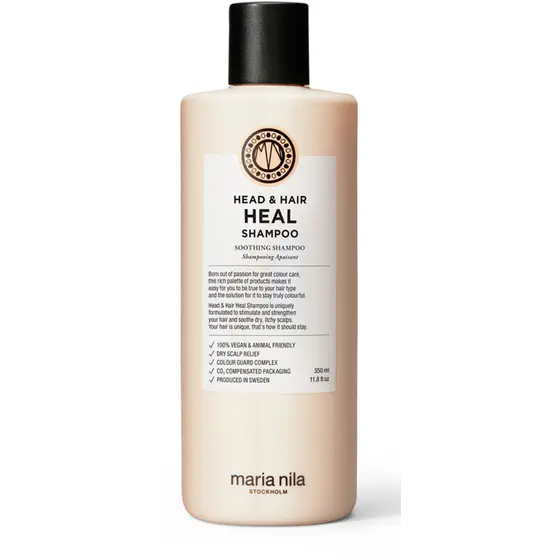 Maria Nila Head & Hair Heal Shampoo -pullo valkoisella taustalla. Pullo on vaalean beige, sylinterimäinen ja siinä on musta korkki sekä vaalea etiketti, jossa lukee “Head & Hair Heal Shampoo”. Pakkaus viestii rauhoittavasta ja päänahkaa hoitavasta shampoosta.